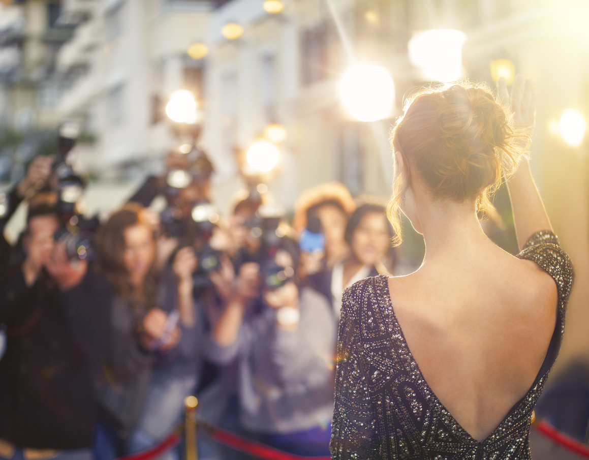 women dressed up in evening gown in front of photographers